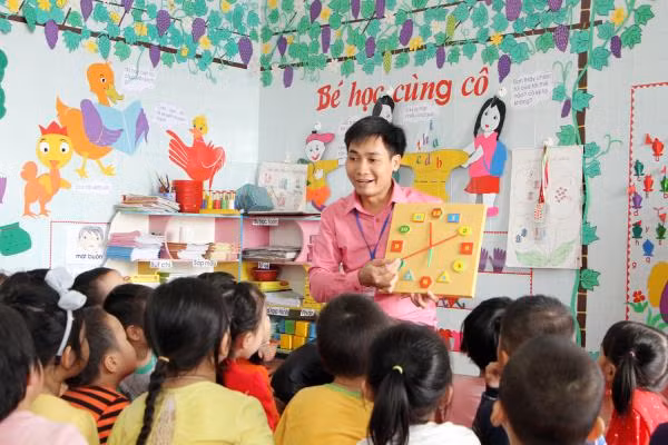 Thầy giáo Vũ Văn Hiên, Hiệu trưởng Trường mầm non Trường Thành (huyện An Lão, Hải Phòng) trực tiếp dạy dỗ các cháu 5 tuổi. (Ảnh: Lã Tiến)