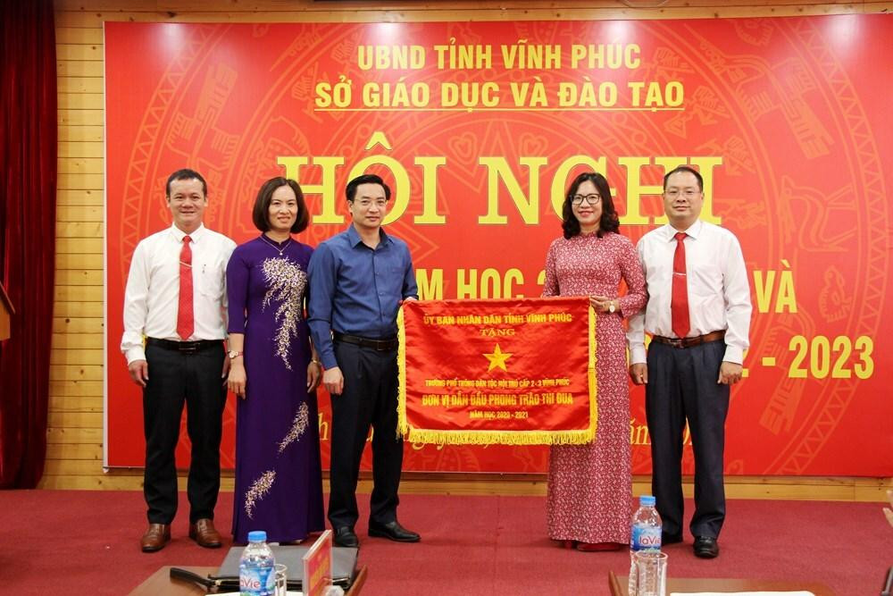 Trao Cờ thi đua của Ủy ban nhân dân tỉnh cho tập thể trường Phổ thông Dân tộc nội trú cấp 2-3 Vĩnh Phúc (nay là trường trung học phổ thông Kim Ngọc). Ảnh: Sở Giáo dục và Đào tạo Vĩnh Phúc