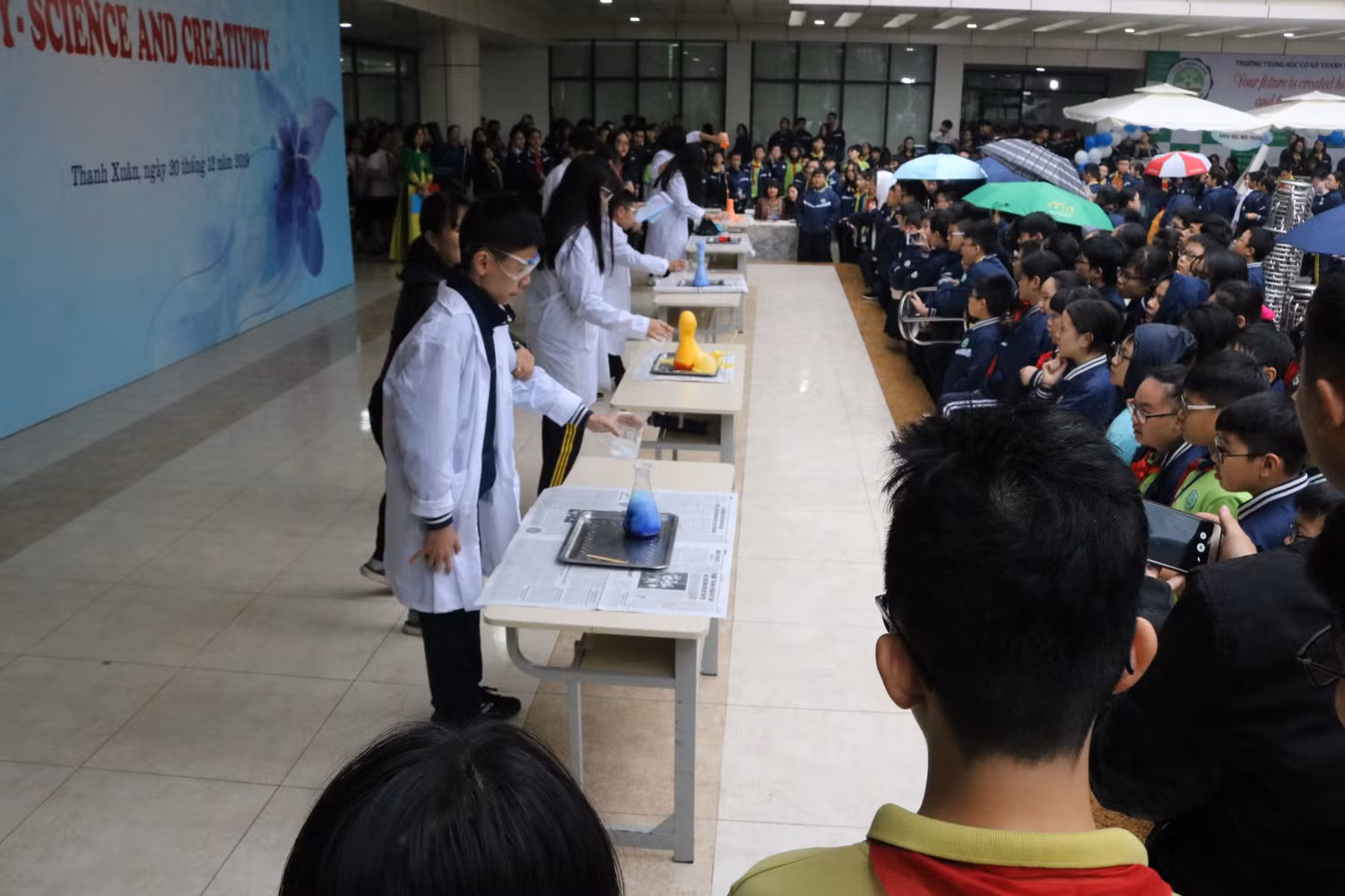 Các học sinh cùng tham gia thí nghiệm núi lửa phun trào ngay trên sân khấu của sự kiện. Ảnh: Đỗ Thơm Các học sinh cùng tham gia thí nghiệm núi lửa phun trào ngay trên sân khấu của sự kiện. Ảnh: Đỗ Thơm