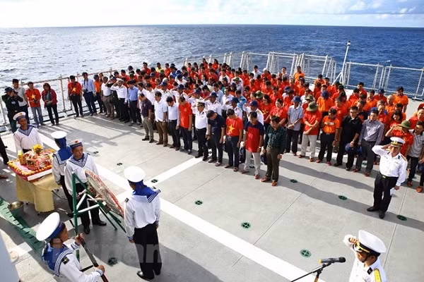 Phút mặc niệm tưởng nhớ anh linh 64 liệt sỹ đã anh dũng ngã xuống tại Gạc Ma (Ảnh: Hồng Kiều/ Vietnam+).