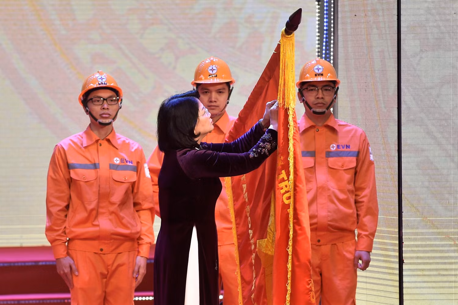 Phó Chủ tịch nước Đặng Thị Ngọc Thịnh gắn danh hiệu Anh hùng Lao động thời kỳ đổi mới lên lá cờ truyền thống của EVN. Ảnh: VGP/Nhật Bắc
