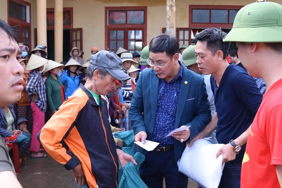Ông Nguyễn Ngọc Quyết (ở giữa) - Tổng Biên tập Tạp chí điện tử Hòa Nhập trao quà cứu trợ cho bà con nhân dân vùng lũ thôn Phú Hòa, xã Phú Thuỷ, huyện Lệ Thuỷ, Quảng Bình.