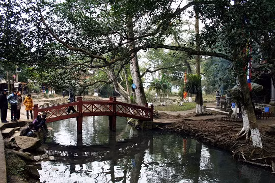 Chiếc cầu sơn đỏ nho nhỏ dẫn vào đền thờ Chàng Rắn. Tương truyền chàng là người đã có công lập làng giữ bản chống chọi với thiên tai giặc giã, mưu cầu bình an, thóc lúa khoai sắn đầy bồ, rượu đầy chum đầy choé. Chiếc cầu sơn đỏ nho nhỏ dẫn vào đền thờ Chàng Rắn. Tương truyền chàng là người đã có công lập làng giữ bản chống chọi với thiên tai giặc giã, mưu cầu bình an, thóc lúa khoai sắn đầy bồ, rượu đầy chum đầy choé.