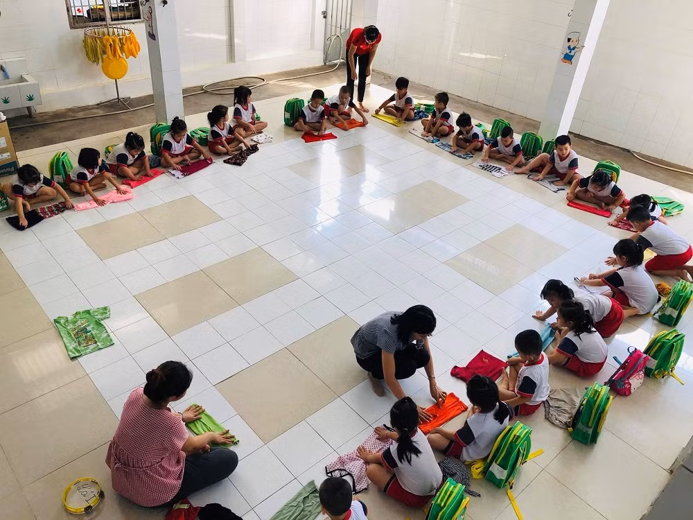 Các cô giáo đang hướng dẫn học sinh gấp quần áo chuẩn bị tặng các bạn vùng sâu, vừa giáo dục kĩ năng sống, vừa giáo dục lòng yêu thương con người Các cô giáo đang hướng dẫn học sinh gấp quần áo chuẩn bị tặng các bạn vùng sâu, vừa giáo dục kĩ năng sống, vừa giáo dục lòng yêu thương con người