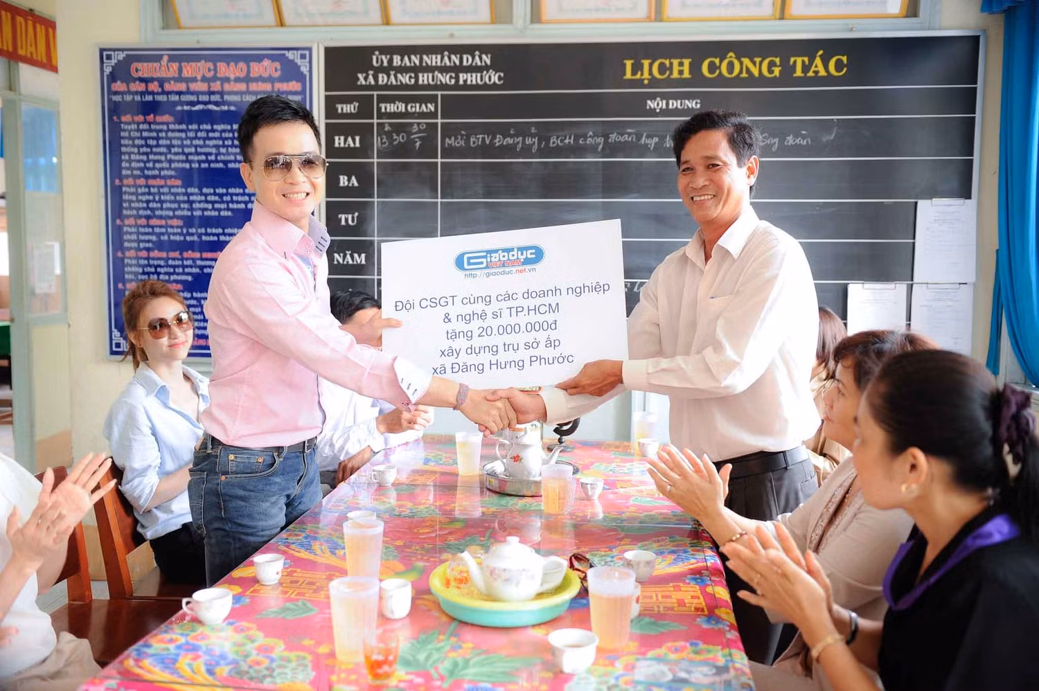 BCa sĩ Hà Oiko, đại diện điện tử Giáo dục Việt Nam và Tập đoàn truyền thông Thanh niên trao 20 triệu đồng cho lãnh đạo xã Đông Hưng Phước.