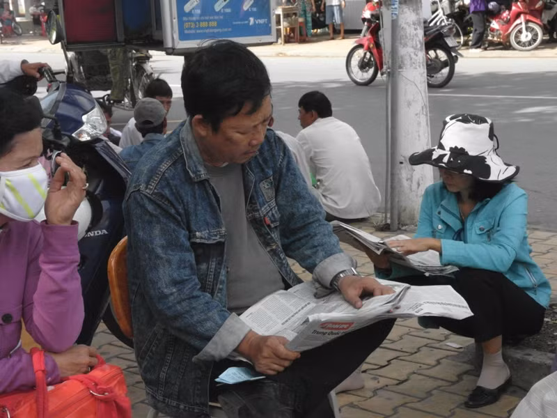 Một ông bố đang thư giãn bằng một tờ báo.