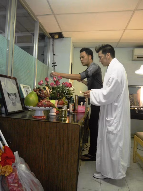 Nơi đây có một bàn thờ nữa. Mr Đàm đã“thỉnh” bàn thờ NSƯT Thanh Nga từ nhà mình vào sân khấu Lan Anh, trong hai ngày liveshhow Số phận diễn ra (21&22/7). Trong ảnh: Một nhân viên thân tín đang giúp Mr Đàm thắp hương…