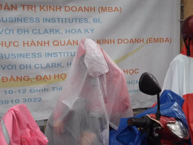 Nếu không đọc chú thích ảnh, ai biết đây là một vị phụ huynh đang ngồi, mặc áo mưa bịt kín?