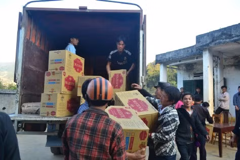 Người dân hỗ trợ bốc dỡ hàng từ xe tải.