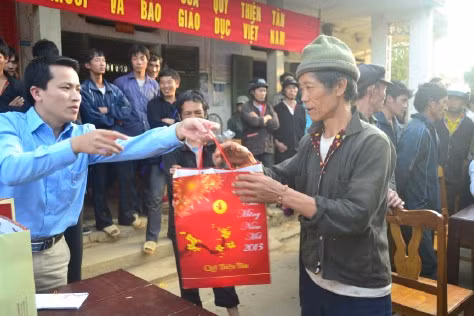Niềm vui của người dân khi nhận được lịch treo tường năm mới, phong bì tiền và bánh kẹo.