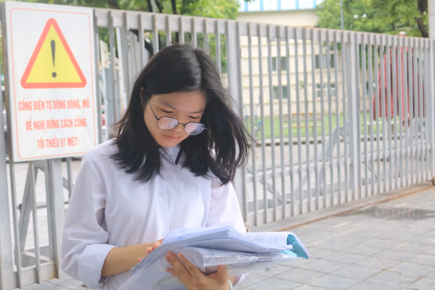 Học sinh Lê Bảo Vy tranh thủ ôn lại bài tại điểm thi Trường Trung học cơ sở Dịch Vọng. Ảnh: Vân Ánh
