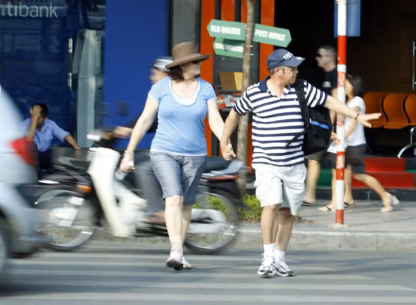 Hai vợ chồng người nước ngoài này ngoài việc giơ tay xin đường phải không ngừng... bước đều bước