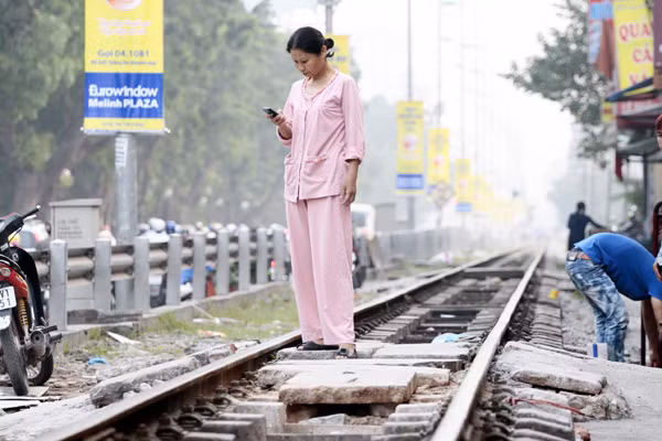 Nghe điện thoại là phải đứng giữa đường tàu như thế này !
