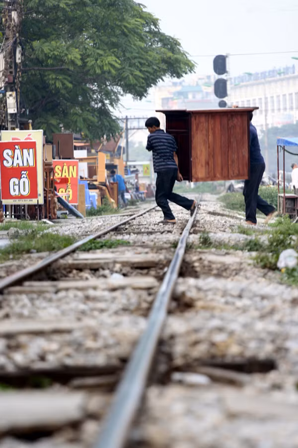 Tranh thủ khênh đồ đạc khi tàu vừa đi qua