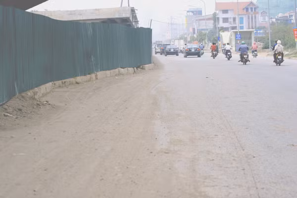 Những lớp bụi đất dày rơi vãi do xe tải chở đất đá đi qua để lại