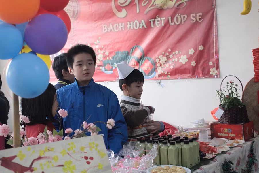 Các em học sinh tham gia bán hàng tại hội chợ.