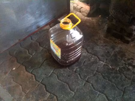 Dưới sàn nhà, một can dầu qua sử dụng đã dùng gần hết. Dưới sàn nhà, một can dầu qua sử dụng đã dùng gần hết.
