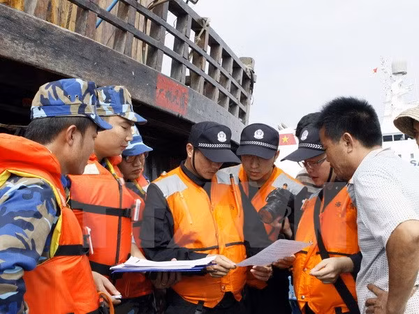 Cảnh sát biển Việt Nam và Cảnh sát biển Trung Quốc kiểm tra giấy phép đánh bắt cá của ngư dân Trung Quốc. Ảnh: TTXVN.