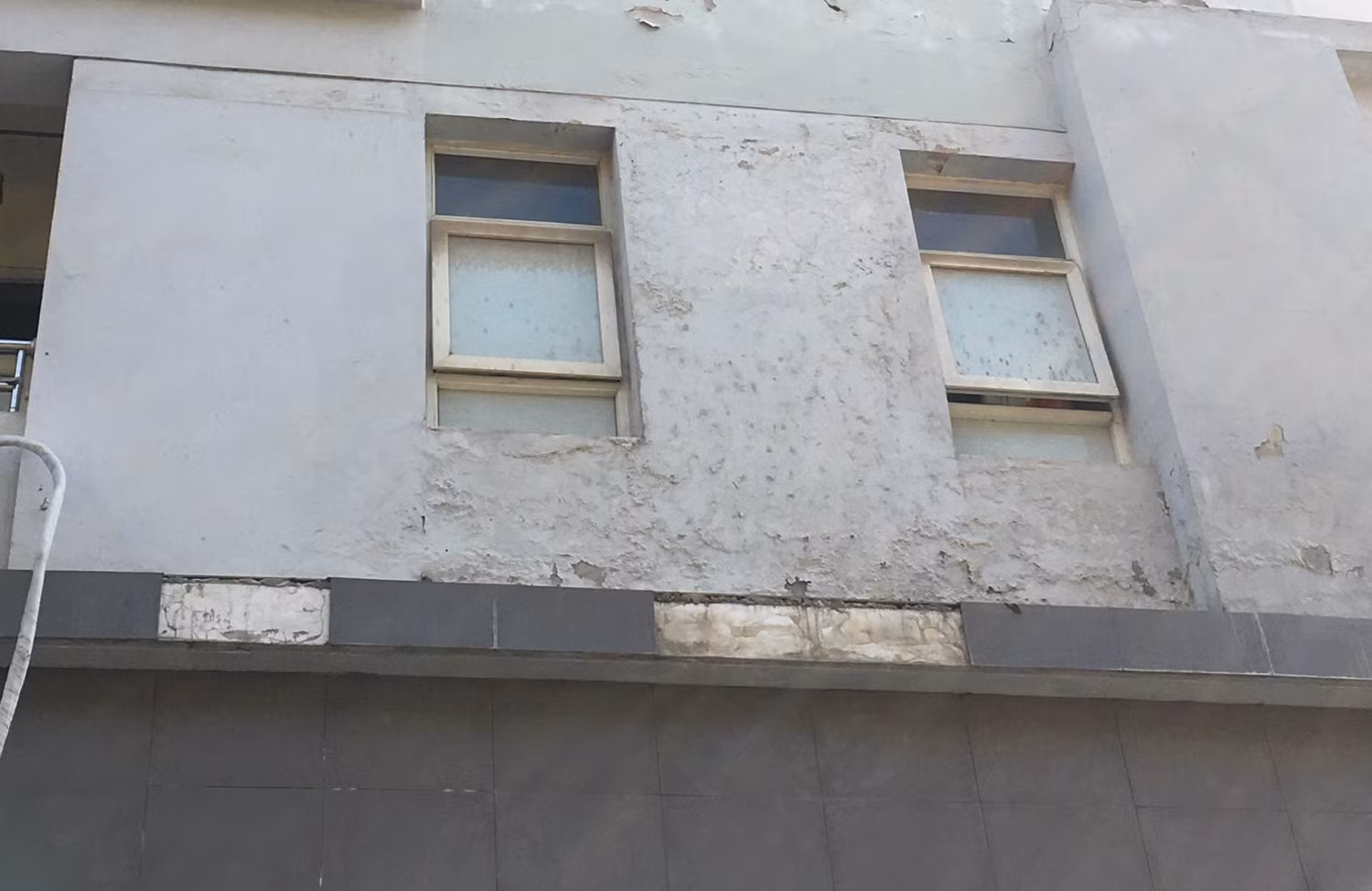 Gạch ốp tường một số tòa nhà rơi xuống rất nguy hiểm. Ảnh: Vũ Phương.