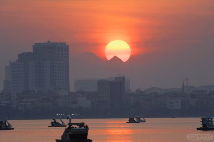 Hoàng hôn xuống, mặt hồ nhẹ lay, in bóng mặt trời đang dần xuống sau dãy núi Tản.