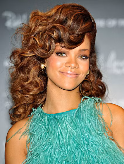 on Rihanna để tóc dài và làm xoăn đầy nữ tính, hất mái lệch khiến khuôn mặt của cô thêm thanh tú.