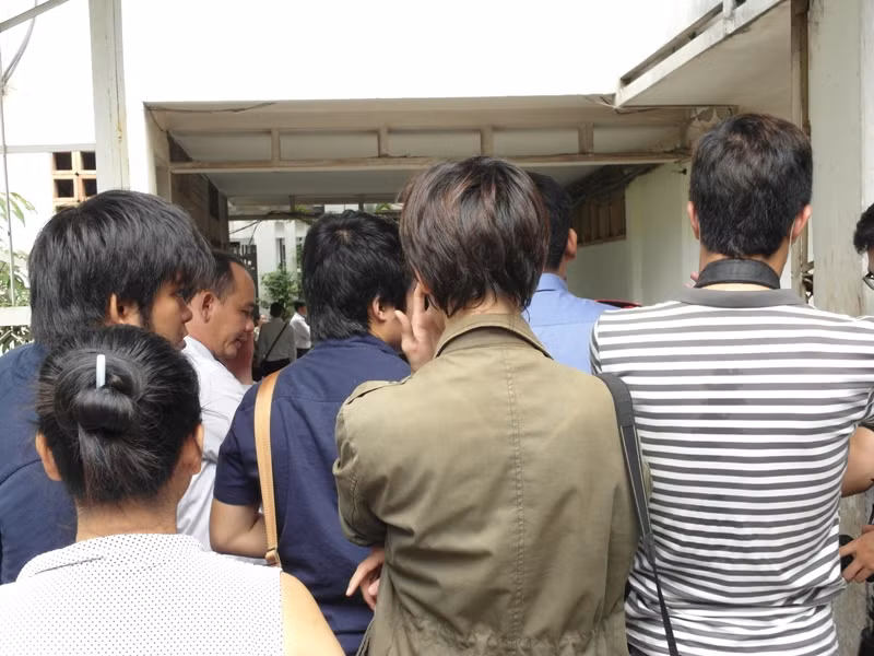 Các phóng viên đang đứng dưới trời nắng, ngay trước cửa vào khu dân cư. Các phóng viên đang đứng dưới trời nắng, ngay trước cửa vào khu dân cư.