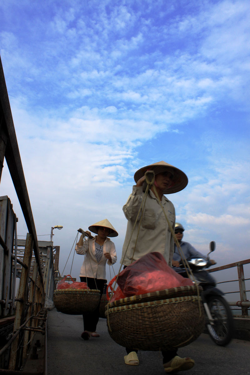 Mỗi sớm bình minh, bạn dễ dàng bắt gặp cảnh các cô, các chị quẩy trên vai những "gánh mưu sinh" nặng trĩu.