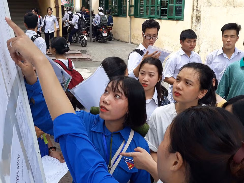 Các sinh viên tình nguyện hướng dẫn các thi sinh tìm phòng thi để làm thủ tục.