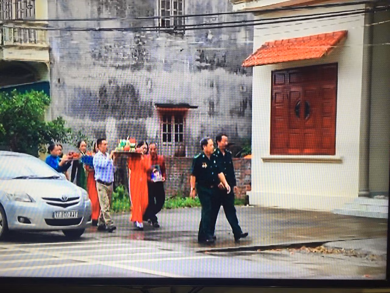 Ông Hoàng Như Lý cùng gia đình liệt sĩ Bùi Văn Lượng đem theo di ảnh của "chú rể" đến nhà "cô dâu" Hoàng Thị Hồng Chiêm nói chuyện trầu cau. (Ảnh chụp lại từ màn hình)