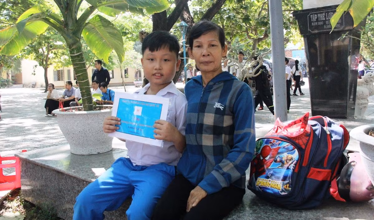 Niềm vui của hai mẹ con chị Nguyễn Thị Huệ khi nhận được học bổng. Ảnh: TT Niềm vui của hai mẹ con chị Nguyễn Thị Huệ khi nhận được học bổng. Ảnh: TT
