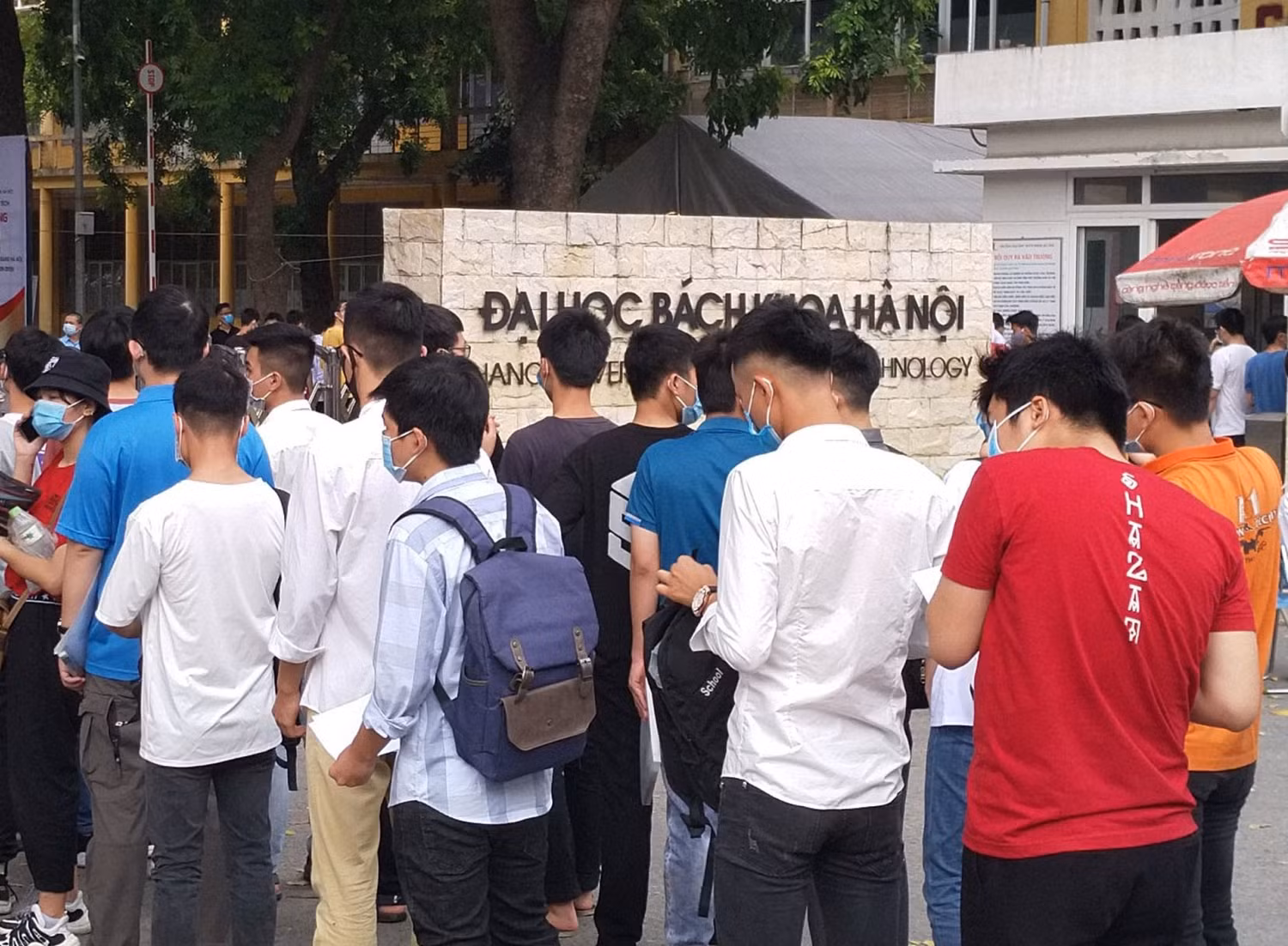 Học sinh xếp hàng trước cổng trường để đo thân nhiệt trước khi thi (ảnh: Phạm Minh)
