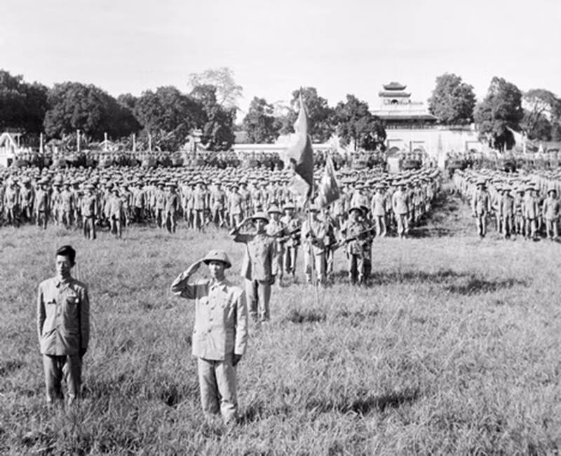 Thiếu tướng Vương Thừa Vũ (bên phải), Tư lệnh Đại đoàn 308, Chủ tịch Ủy ban Quân chính thành phố và bác sỹ Trần Duy Hưng (bên trái), Phó Chủ tịch Ủy ban Quân chính cùng các đơn vị thuộc Đại đoàn 308 tiếp quản Hà Nội tiến hành nghi lễ chào cờ đầu tiên trong Ngày giải phóng Thủ đô, diễn ra tại sân Cột Cờ (nay là Đoan Môn-Hoàng thành Thăng Long) vào lúc 15 giờ ngày 10/10/1954. (Ảnh: Tư liệu TTXVN)