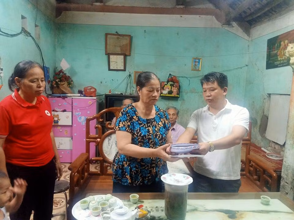 Ông Nguyễn Văn Oánh - Chủ tịch Ủy ban Nhân dân xã Văn Bình trao tiền quyên góp của các nhà hảo tâm cho người nhà của chị Thơm.
