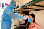Cán bộ tổ công tác đo thân nhiệt cho người dân trong khu cách ly trường quân sự Sơn Tây. (Ảnh: TTXVN)