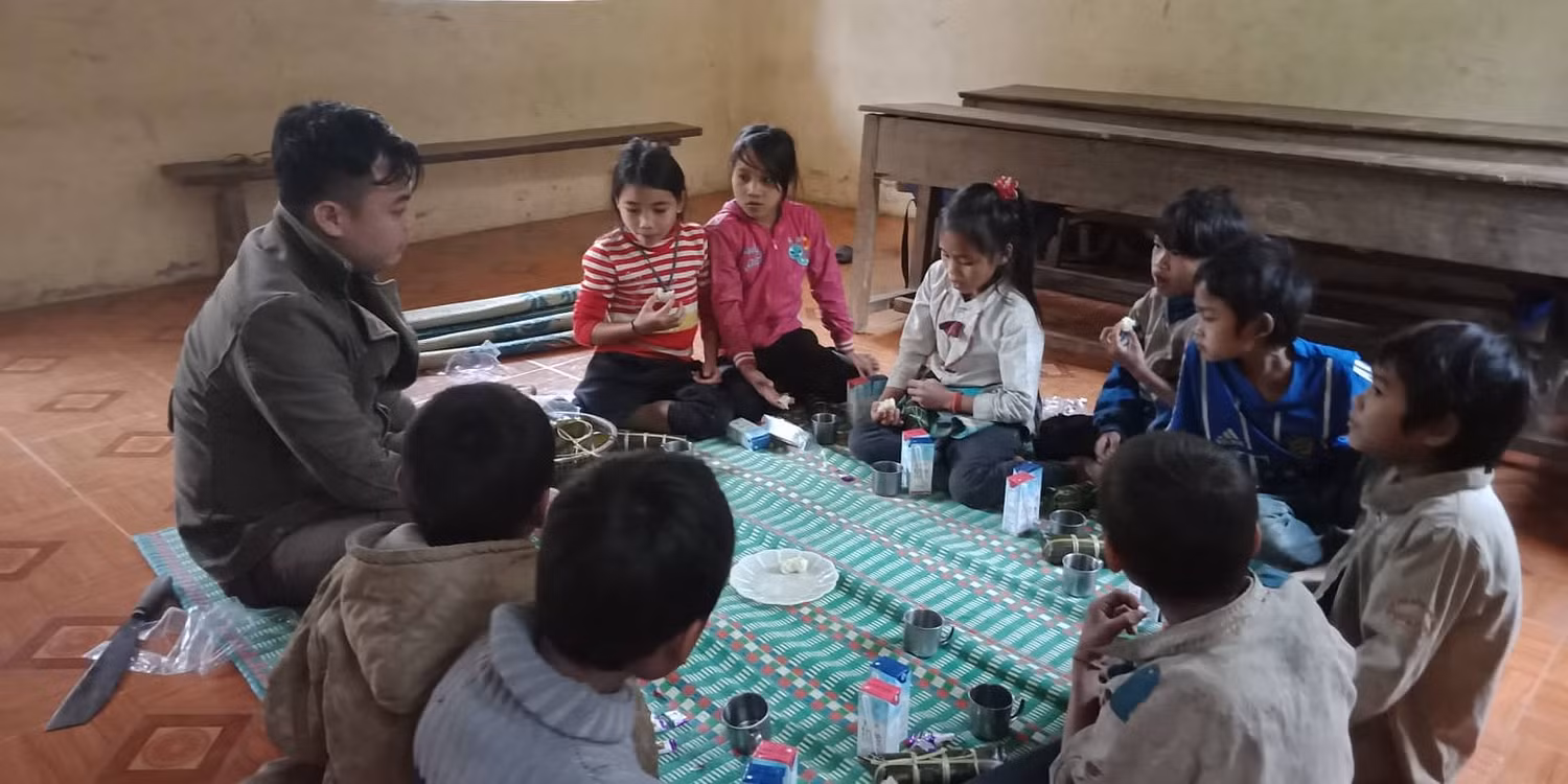 Vừa được ăn, các em học sinh vừa được nghe thầy giáo kể về Tết là gì.