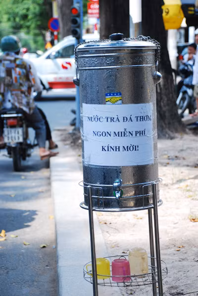 Người nấu trà đá còn trân trong kính mời người đi đường. Ảnh Báo TNO
