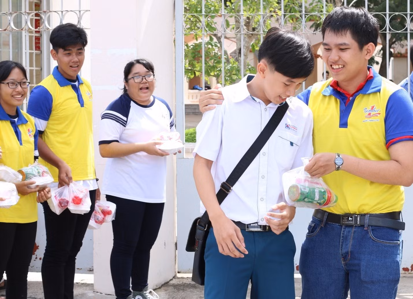 Các tình nguyện viên trao phần cơm trưa cho các thí sinh bên ngoài cổng trường Các tình nguyện viên trao phần cơm trưa cho các thí sinh bên ngoài cổng trường