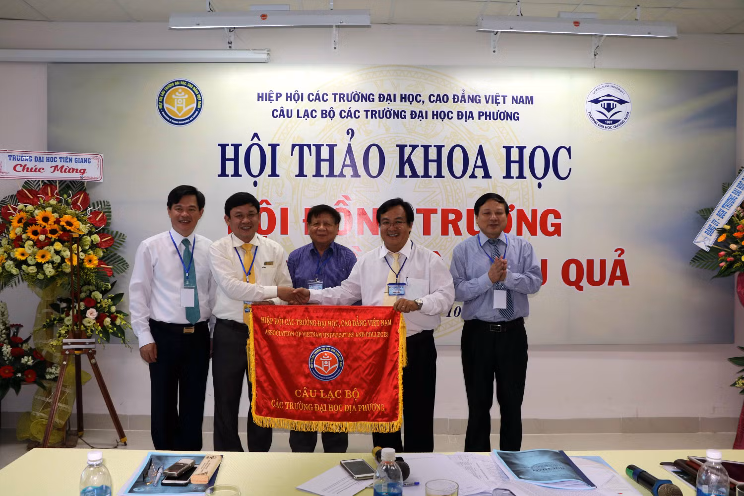 Phó giáo sư, Tiến sĩ Huỳnh Trọng Dương – Hiệu trưởng Trường Đại học Quảng Nam trao cờ luân lưu cho đại diện lãnh đạo Trường Đại học Tiền Giang Phó giáo sư, Tiến sĩ Huỳnh Trọng Dương – Hiệu trưởng Trường Đại học Quảng Nam trao cờ luân lưu cho đại diện lãnh đạo Trường Đại học Tiền Giang