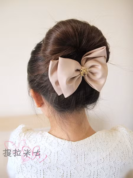 Thêm nơ ở phía dưới để nâng mái tóc đồng thời không cho bối tóc bung ra. Chúc bạn thành công.
