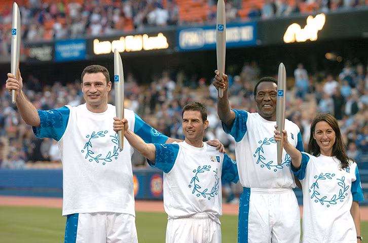 Vitali Klitschko, Tom Cruise, Rafer Johnson và Janet Evans, Lễ rước đuốc Olympic, Sân vận động bóng chày Dodgers, LA, 2004. Khi bạn nhận ra rằng mình đang mặc một chiêc quần cạp chun đi cùng với tông màu của những năm 80, và đứng trước hàng ngàn người, điều duy nhất bạn có thể làm là tươi cười. Chúng quá đơn giản và cần thêm một chút phụ kiện.