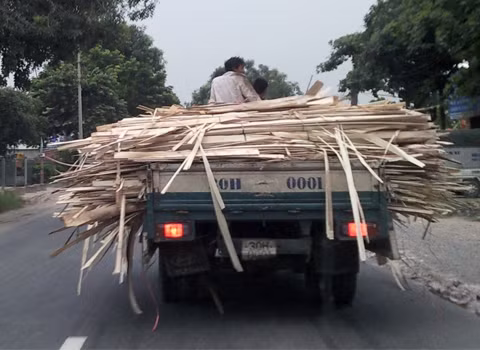 Ngồi trên thùng xe tải rất nguy hiểm. Ảnh: Pham Ngoc Vu