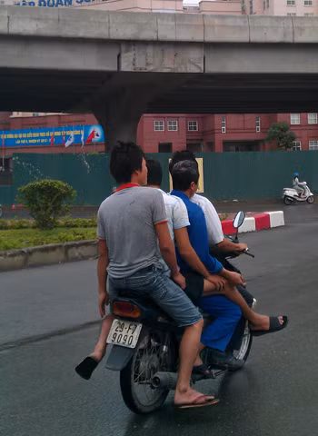 4 người ngồi trên xe máy chạy dưới chân cầu Linh Đàm, Hà Nội.