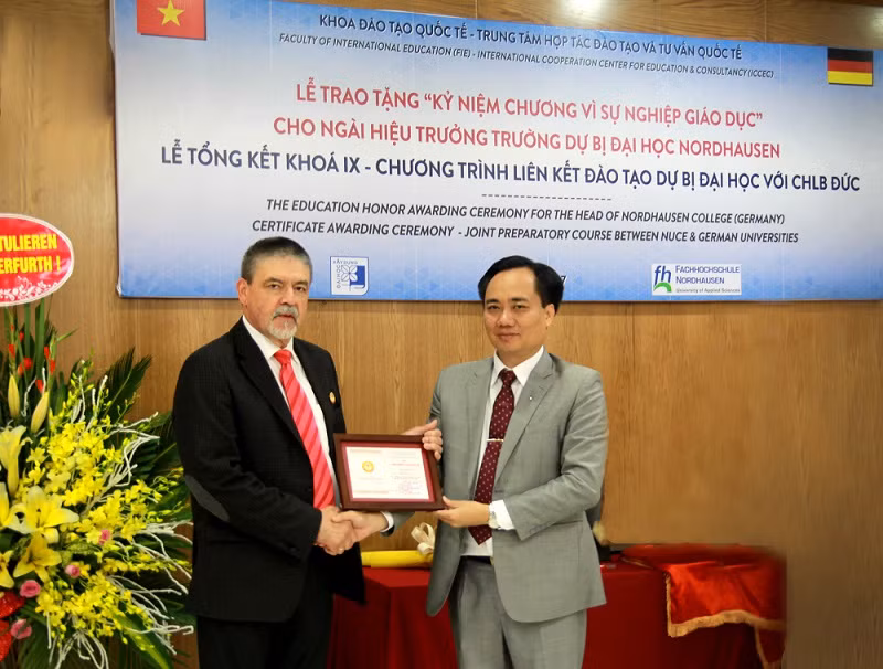 Nhận ủy quyền của Bộ Giáo dục và Đào tạo, Hiệu phó trường Đại học Xây dựng – Phó giáo sư Phạm Xuân Anh (bên phải) trao kỷ niệm chương “Vì sự nghiệp giáo dục” cho Giáo sư Herfurth diễn ra ngày 7/7/2017. (Ảnh: Thùy Linh) Nhận ủy quyền của Bộ Giáo dục và Đào tạo, Hiệu phó trường Đại học Xây dựng – Phó giáo sư Phạm Xuân Anh (bên phải) trao kỷ niệm chương “Vì sự nghiệp giáo dục” cho Giáo sư Herfurth diễn ra ngày 7/7/2017. (Ảnh: Thùy Linh)
