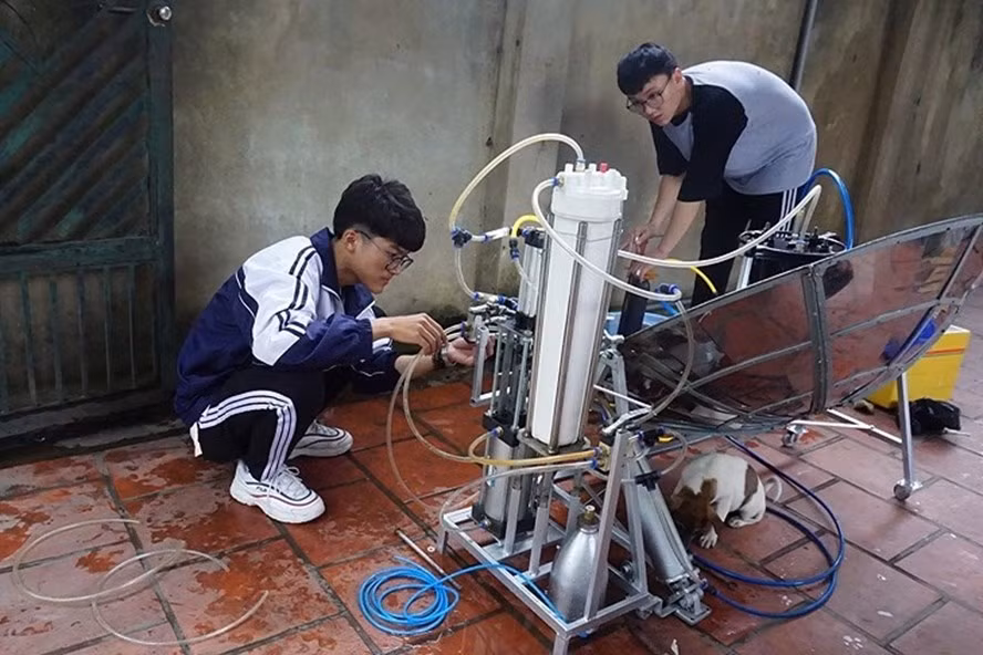 Em Nhật Anh (trái) và Văn Long đang kiểm tra dự án thiết bị "hô biến" nước mặn thành nước ngọt bằng năng lượng sóng biển. (Ảnh: Báo Lao động)