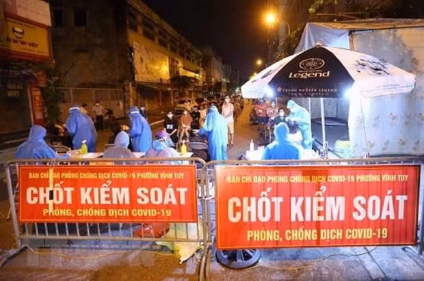 Nhân viên y tế quận Hai Bà Trưng (Hà Nội) tổ chức 4 dây chuyền lấy mẫu xét nghiệm COVID-19 cho người dân phố Mạc Thị Bưởi, phường Vĩnh Tuy ngay trong đêm. (Ảnh: Hoàng Hiếu/TTXVN)