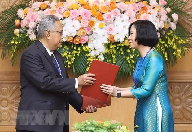 Tổng Giám đốc Thông tấn xã Việt Nam Vũ Việt Trang và Tổng biên tập Hãng thông tấn quốc gia Malaysia (BERNAMA) Khairdzir Md Yunus trao đổi Thỏa thuận hợp tác nghiệp vụ giữa Thông tấn xã Việt Nam và Hãng thông tấn quốc gia Malaysia. (Ảnh: Dương Giang/TTXVN)