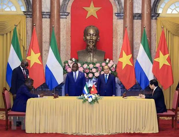 Chủ tịch nước Nguyễn Xuân Phúc và Tổng thống nước Cộng hòa Sierra Leone Julius Maada Bio chứng kiến lễ ký kết hợp tác giữa hai nước. (Ảnh: Thống Nhất/TTXVN) Chủ tịch nước Nguyễn Xuân Phúc và Tổng thống nước Cộng hòa Sierra Leone Julius Maada Bio chứng kiến lễ ký kết hợp tác giữa hai nước. (Ảnh: Thống Nhất/TTXVN)