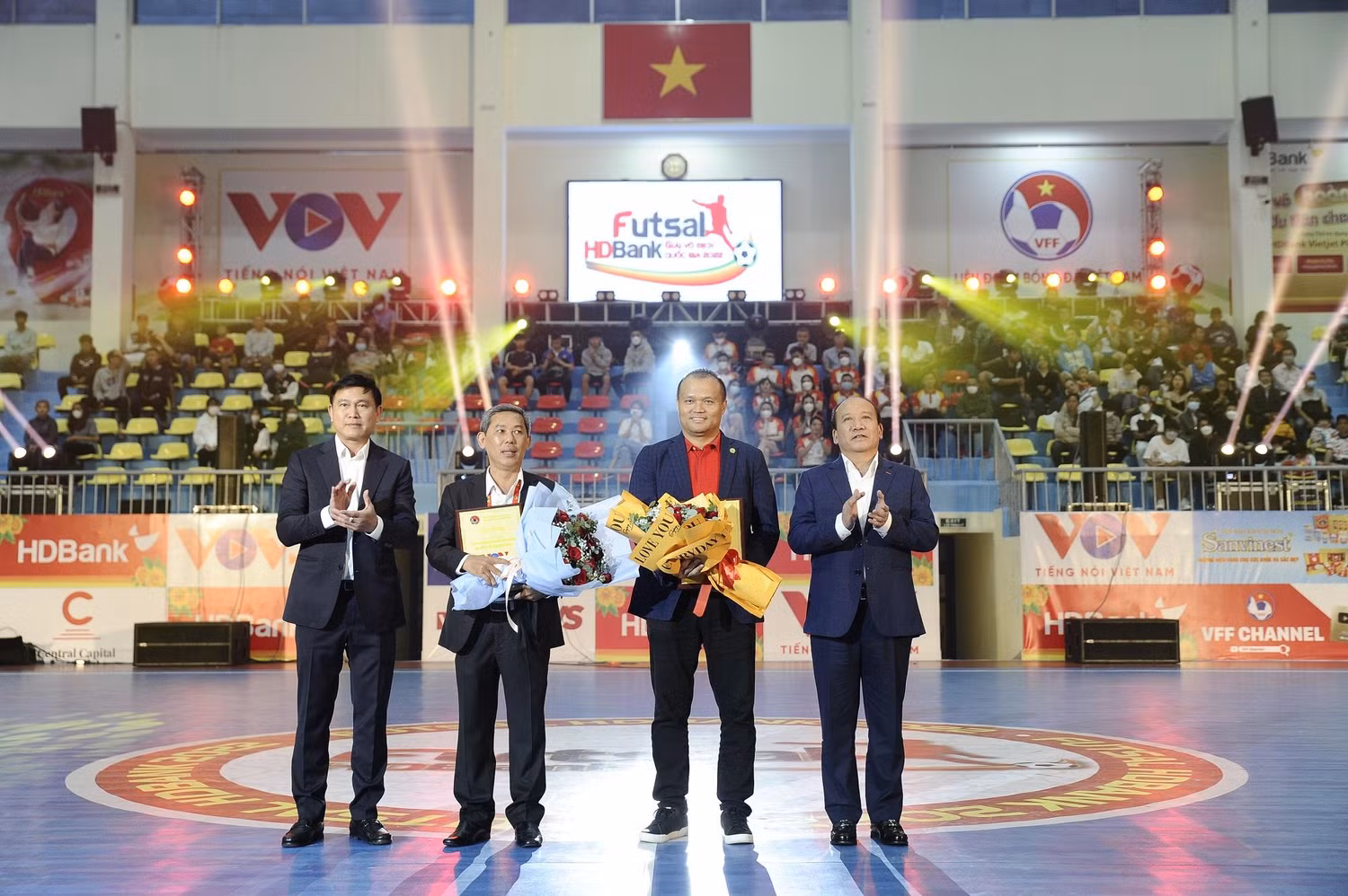 Ông Trần Minh Hùng Phó Tổng giám đốc Đài Tiếng nói Việt Nam, Phó Chủ tịch Ủy ban Olympic Việt Nam, đồng Trưởng Ban tổ chức giải Futsal HDBank Vô địch quốc gia 2022 (bìa phải) trao hoa và kỷ niệm chương cho ông Nguyễn Đăng Thanh – Phó Tổng giám đốc HDBank (thứ hai từ phải qua), đại diện đơn vị đồng hành cùng giải đấu.
