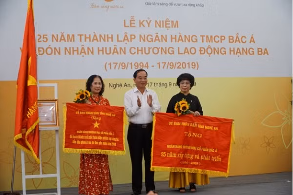 Đồng chí Hoàng Viết Đường, Phó Chủ tịch Hội đồng nhân dân tỉnh Nghệ An trao tặng Cờ thi đua xuất sắc 2018 và Bức trướng chúc mừng cho BAC A BANK.