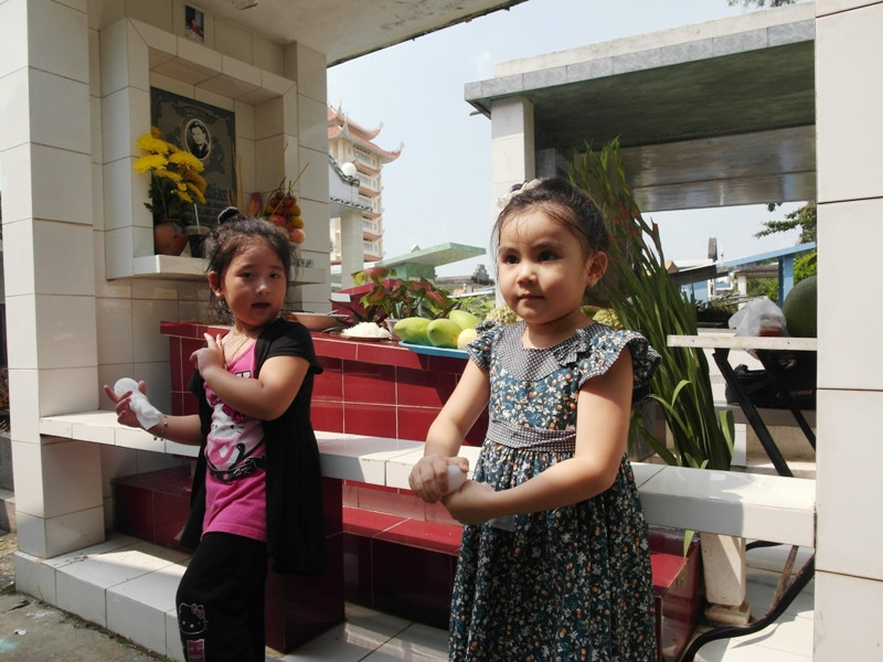 Bí Ngô (con gái của diễn viên Lê Tuấn Anh) và Hạt Dẻ (con gái của MC Quyền Linh) bên mộ của Lê Công Tuấn Anh.